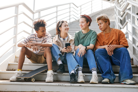 Four teens sitting on a staircase.