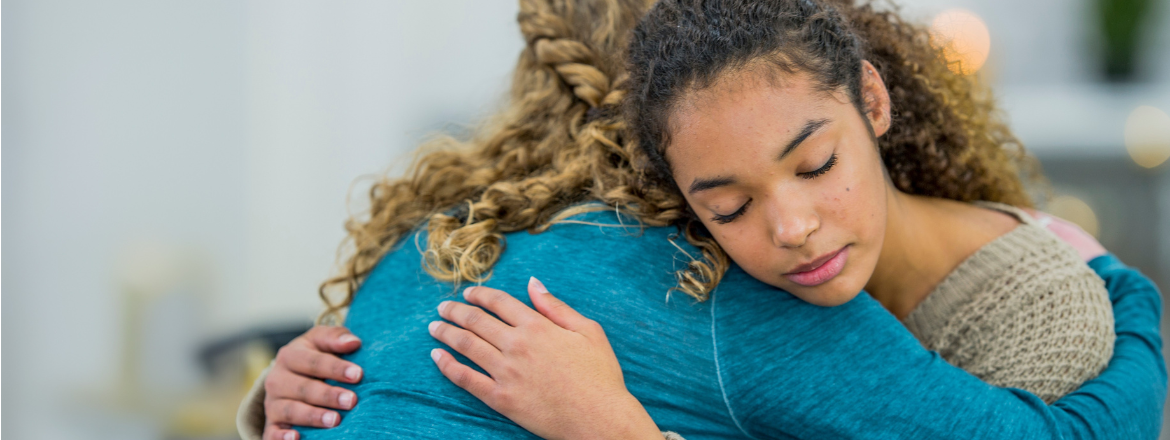 Teen hugging someone.