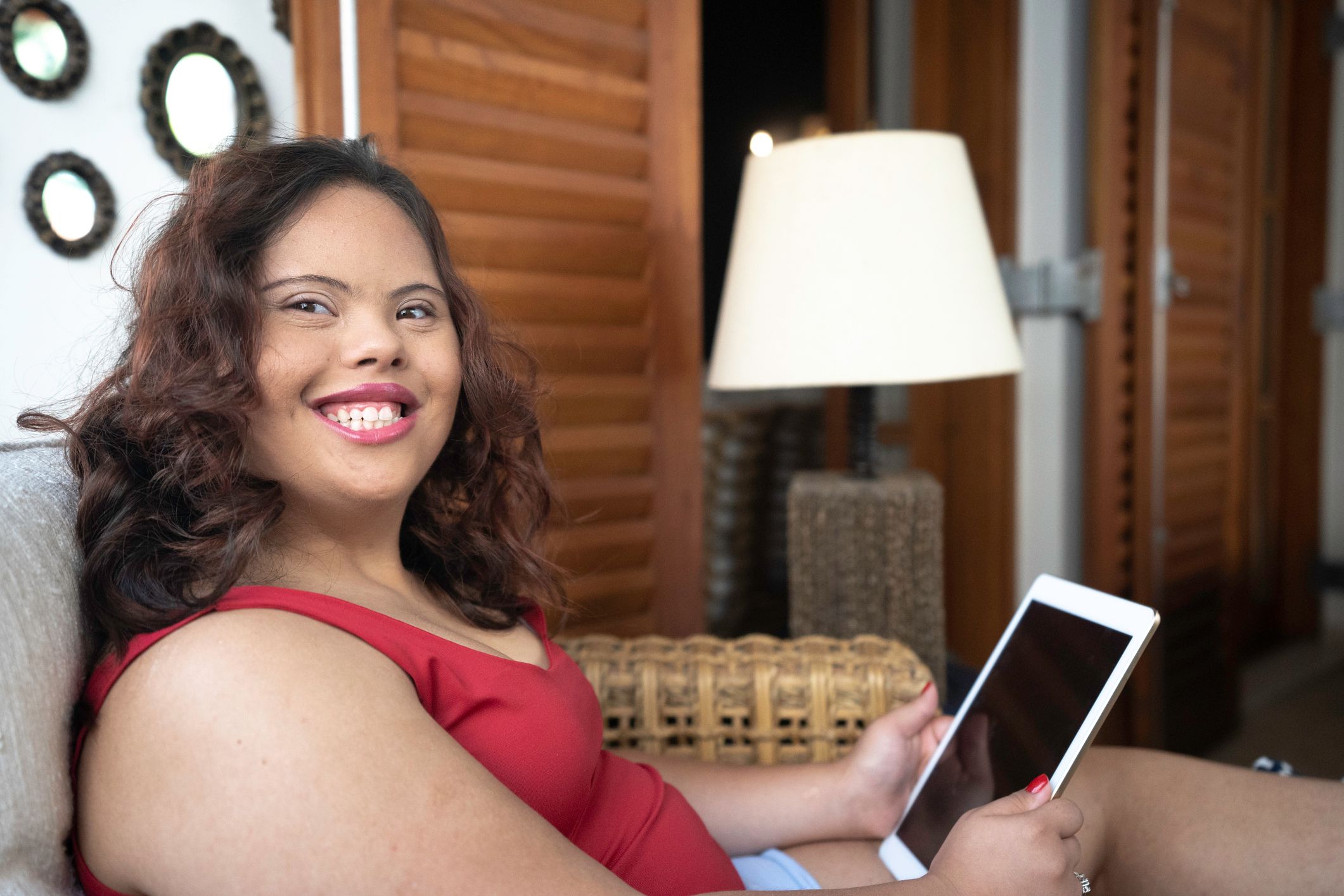 Image of a young woman with intellectual and developmental disability holding a tablet. 