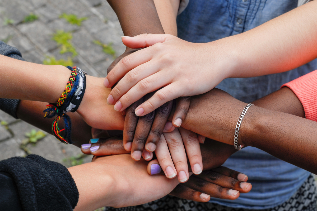 Group of people putting their hands together.