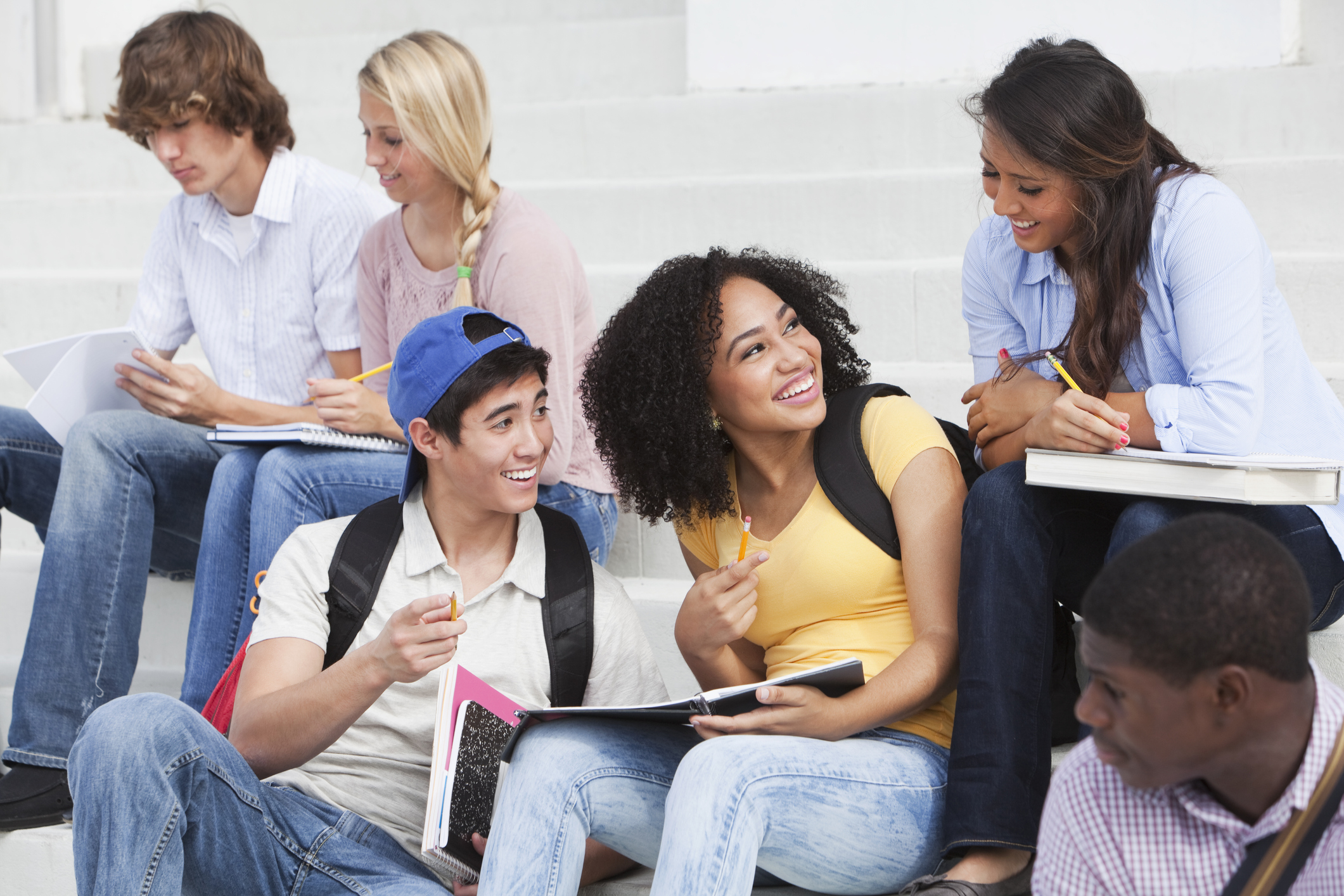 Group of diverse teens sitting on steps