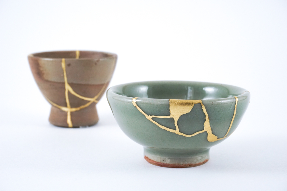 Two Japanese sake cups. Cracks in the cups were mended using Kintsugi gold restoration technique. 