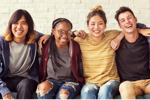 Diverse teens sitting next to one another. 