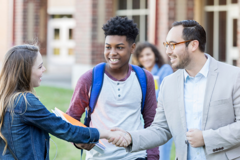 Teacher and student shaking hands.