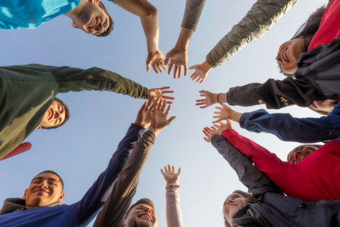 Group of people with their hands raised.