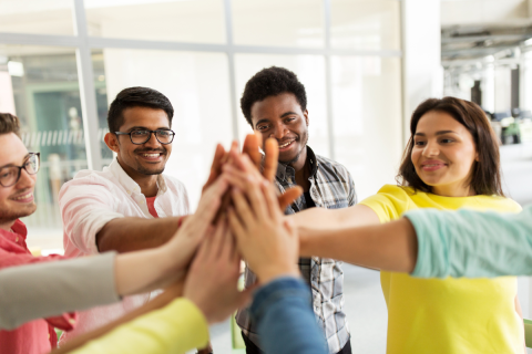 Group of teens high-fiving.