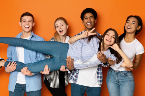 Four adolescents are holding up another as they lay horizontally.