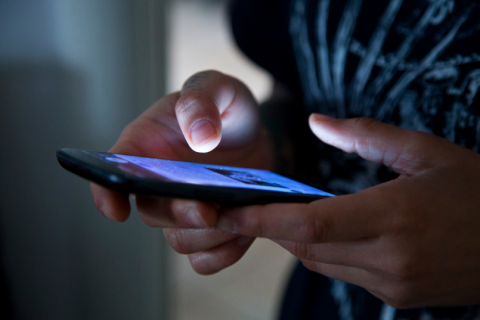 Teen holds phone and scrolls.