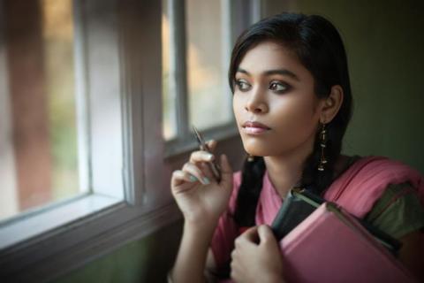 Young Asian woman looking outside