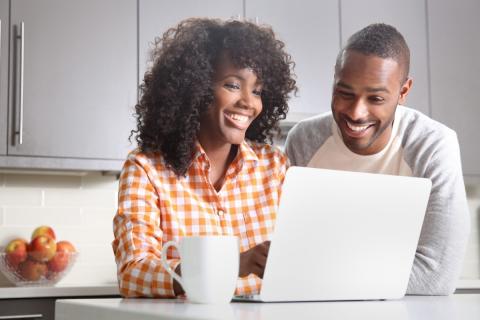 Image of two adults sitting in front of a computer