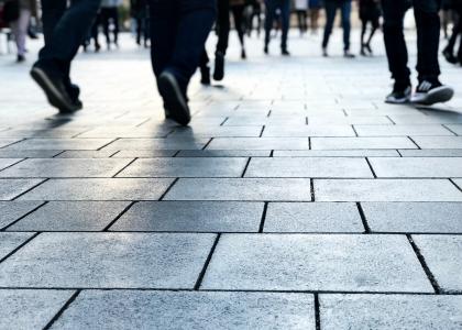 Shoes of people walking on stone in an urban space.  