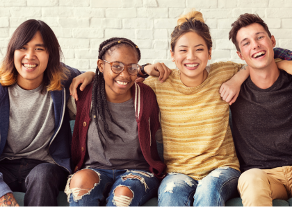 Diverse teens sitting next to one another. 