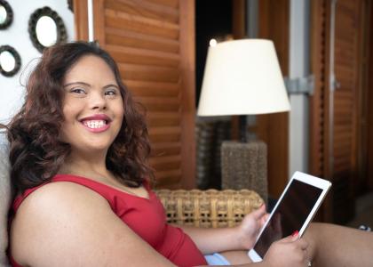 Image of a young woman with intellectual and developmental disability holding a tablet. 