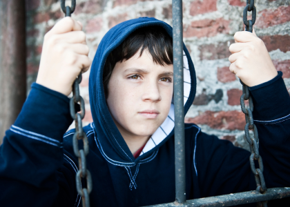 Youth with their hands on chains, looking away from the camera