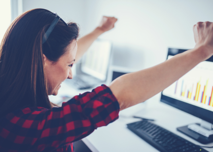 Person making a gesture of success towards a computer