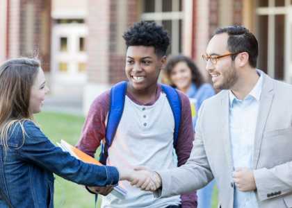 Teacher and student shaking hands.