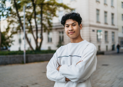 Smiling teen with arms folded.