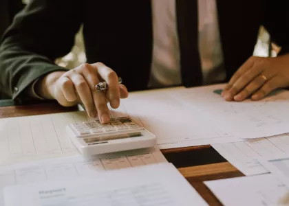Person using a calculator while looking at graphs