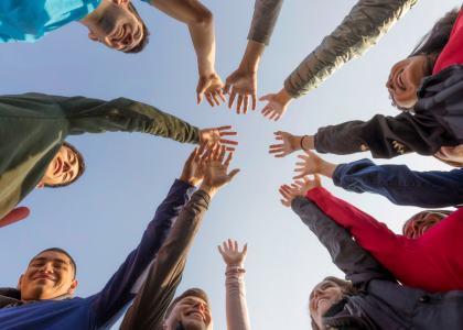 Group of people with their hands raised.