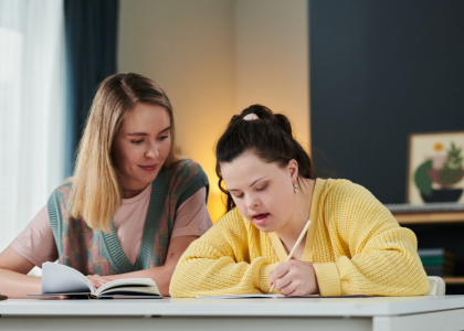 A teacher working with a youth with a disability.