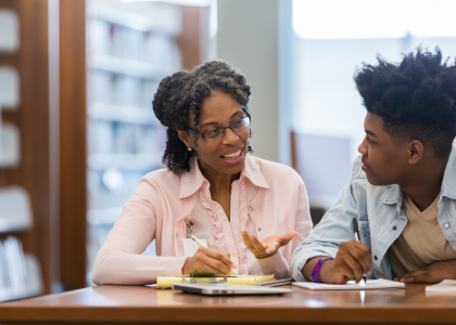 Adult talking to male adolescent.