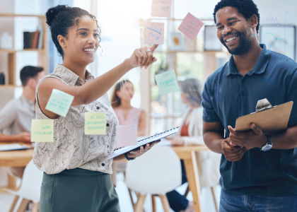 Two people looking at sticky notes. 