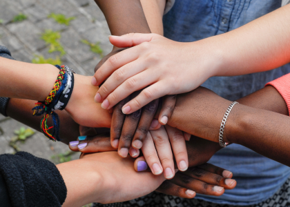 Group of people putting their hands together.