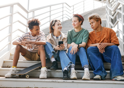 Four teens sitting on a staircase.