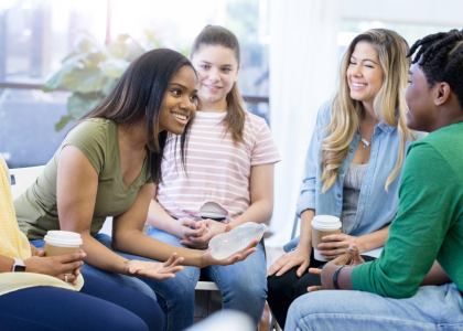 Group of 5 diverse teens sitting in a circle and talking. 