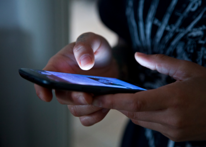 Teen holds phone and scrolls.