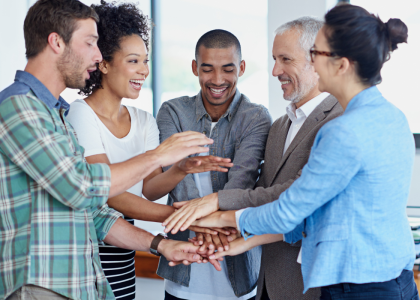 A group of coworkers putting their hands together.