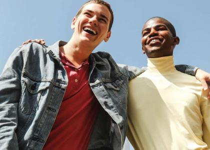 Two young people smiling and looking out into the distance.