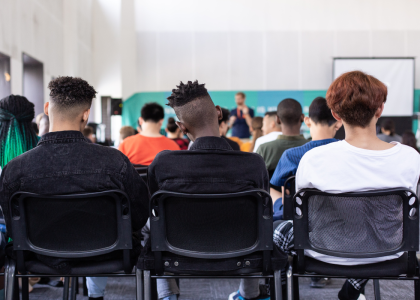 Image that shows a group of teenage boys from behind sitting in a classroom