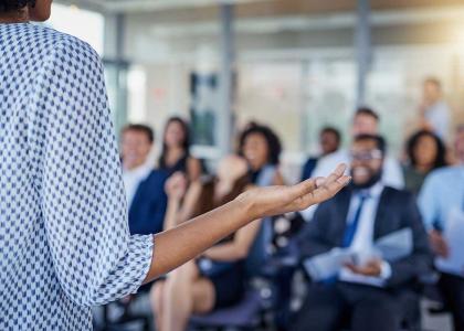 Woman presenting to a group of professionals.