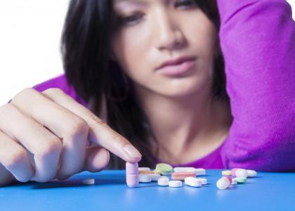 Girl looking at pills.