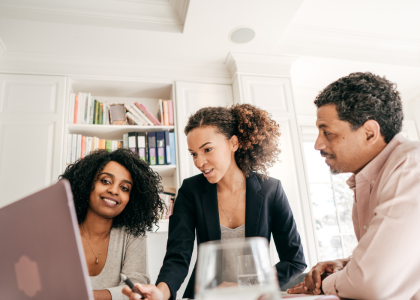 Three people around a laptop