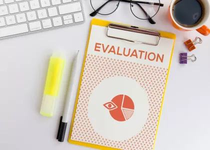 A clipboard on a desk with the word Evaluation. 