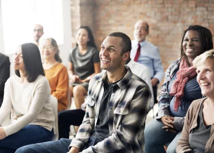 A group of smiling adults face an instructor. 