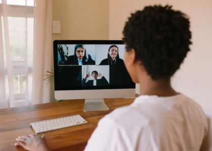 An adult working professional tunes into a zoom meeting.