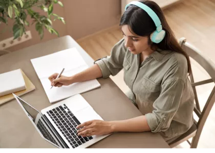 A teen girl works at her laptop in a Zoom class.