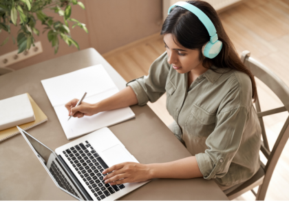 A teen girl works at her laptop in a Zoom class.