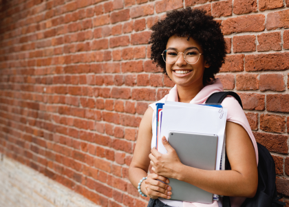 Teen girl standing in front of a brick wall