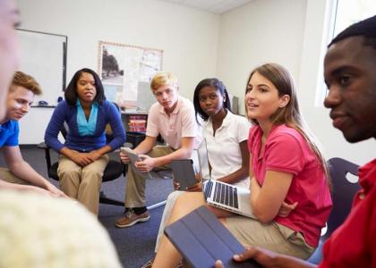 Group of teens talking to teacher