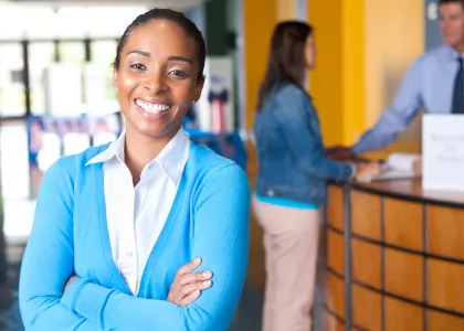 Young professional African American woman stands in office.