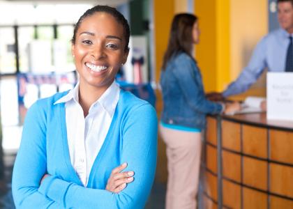 Young professional African American woman stands in office.