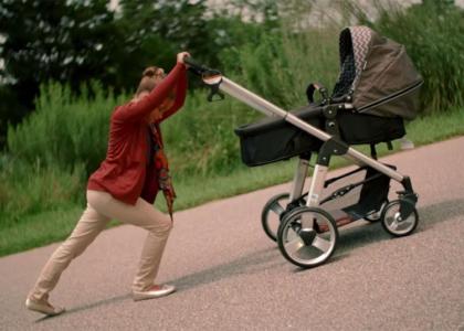 Young girl pushing stroller up hill