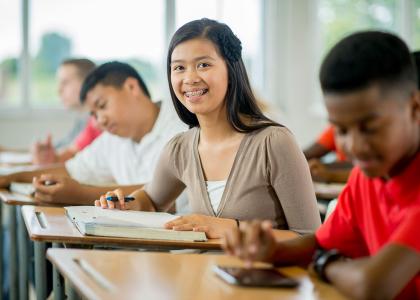 Young girl taking notes in class.