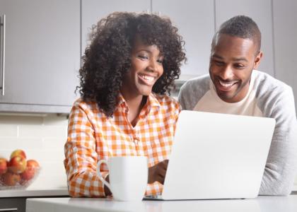 Image of two adults sitting in front of a computer