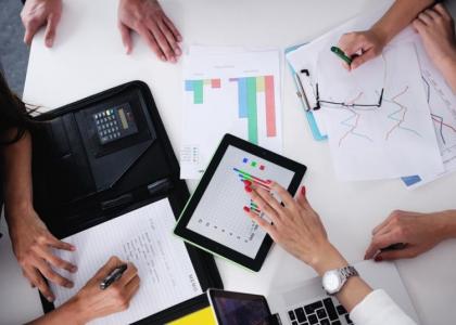 Above view of a business team working on a project using a computer tablet